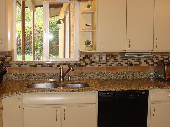Kitchen w/Granite Counters, Glass Tile, and Stainless/Black Appliances