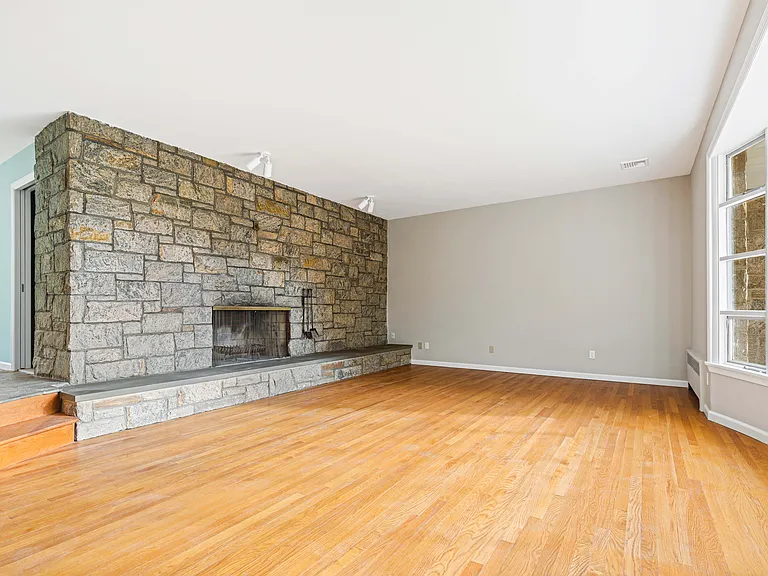 sunken living room with original stone fireplace