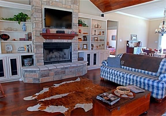 Enter to soaring ceilings, rock fireplace (gas or wood burning), built in shelves and cabinets with upper lighting for a softer look, surround sound, rustic hardwoods on floors and celings, and so much more!