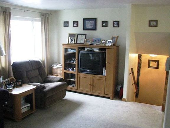 Living room with stairs down to entry.