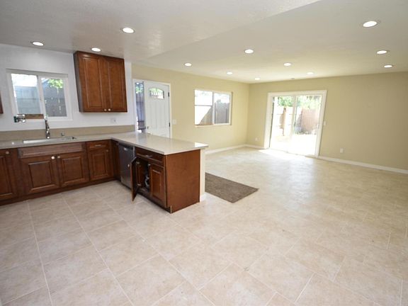OPEN FLOOR PLAN WITH SLIDING GLASS DOOR LEADING TO BACK YARD AND COVERED PATIO.