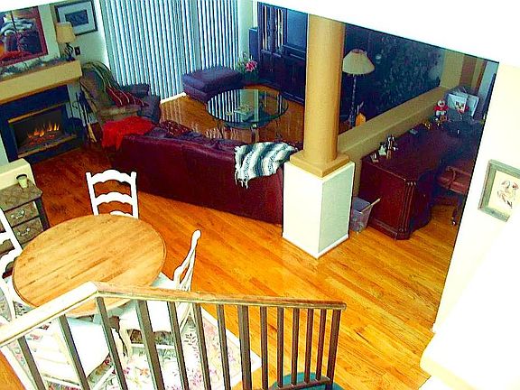 View of Living Room from staircase, with Dining Room in the lower left corner. Note the fireplace at the top left, which is gas and wood burning. 

The Kitchen Nook is visible at the right side.