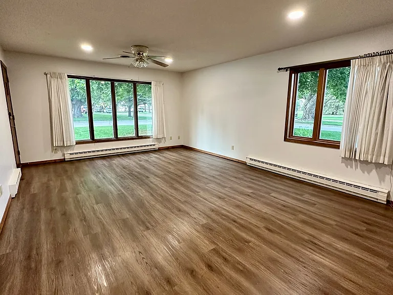 The living room features newly installed recessed LED can lighting throughout, providing bright, even illumination and a modern feel. Combined with large picture windows and a ceiling fan/light fixture, the space is exceptionally bright and inviting.
