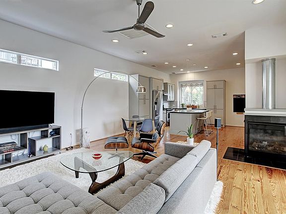 Second floor living room has wood floors, a gas-log fireplace, recessed lighting, and expansive wall space for displaying art.