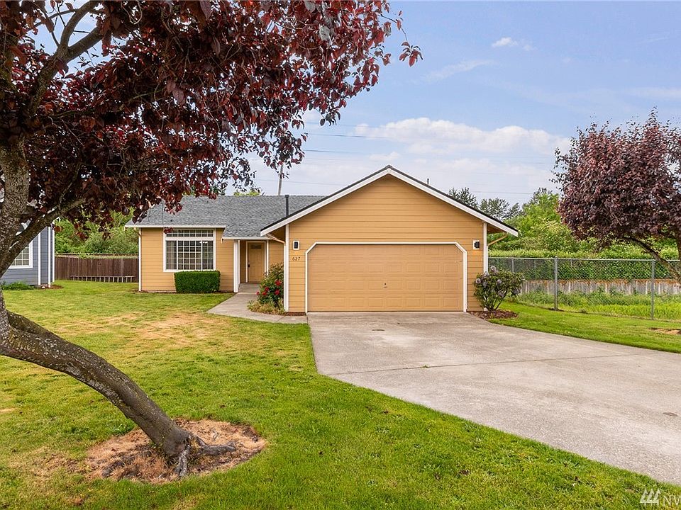 Flanked by trees, a long driveway leads to this adorable rambler. 