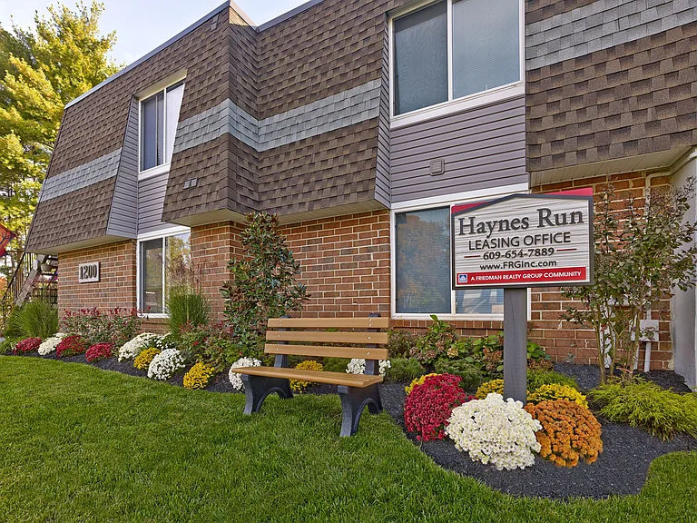 Haynes Run Apartments Leasing Office entrance surrounded by seasonal landscaping in Medford, NJ.