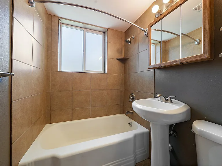 Bathroom with large frosted window to backyard, shelves and medicine cabinet