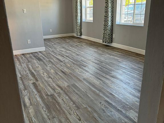 Living room with plenty of natural light, dining nook adjacent to kitchen.