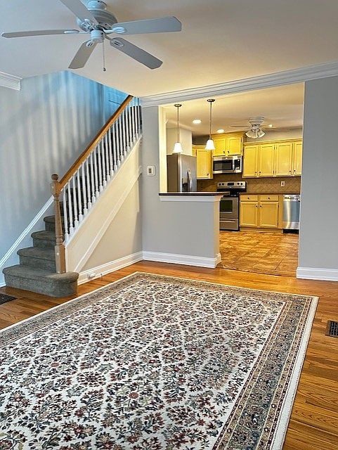 Open Living Space ~ LR w/ Hardwood Fls. Kitchen w/tile floor, new S/S appliances, pendant lights over island w/seating.