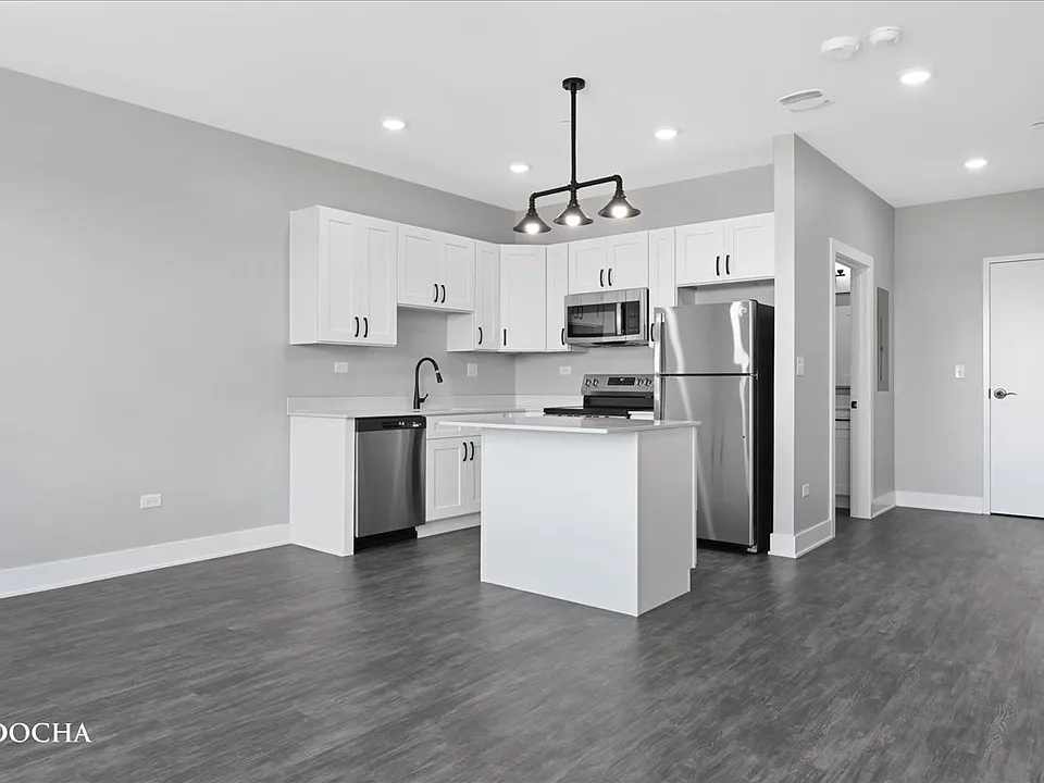 Spacious studio apartment with all stainless steel appliances, granite countertops, white cabinets, and in unit washer and dryer