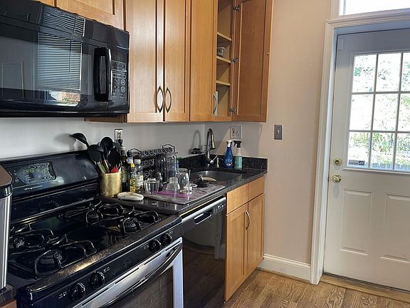 Kitchen with granite countertops, stainless steel gas stove, microwave, dishwasher