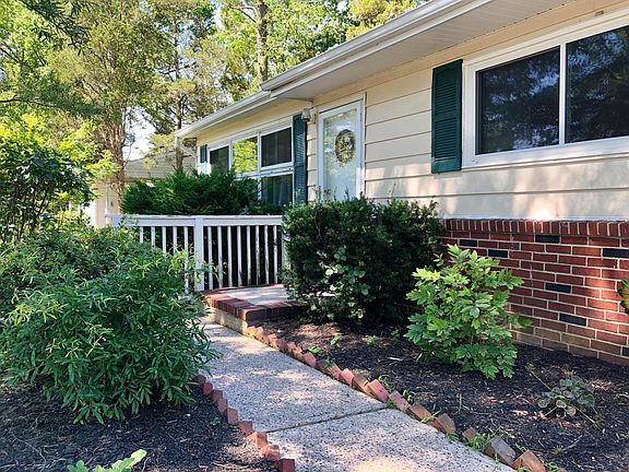 Front door with sidewalk and cleanly kept bushes