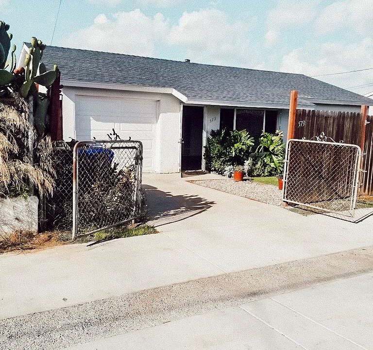 Fully fenced home with attached garage and alley access parking.