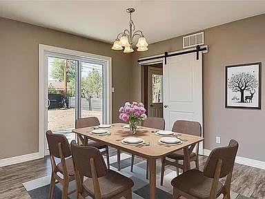 Dining with sliding door to backyard and barn door into laundry and garage entrance