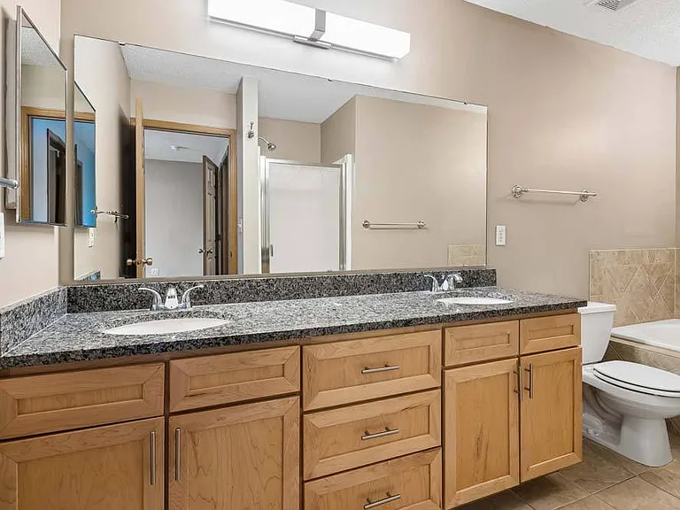 A spacious double vanity with warm cabinetry and sleek countertops, designed to make daily routines feel effortless.