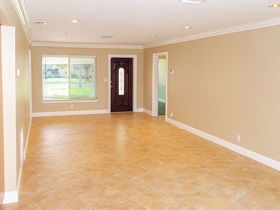 This photo captures the living room and main entrance of the house, taken from the perspective of the kitchen.