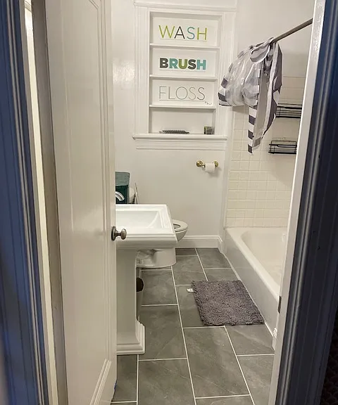 Bathroom has new flooring, sink, and toilet.