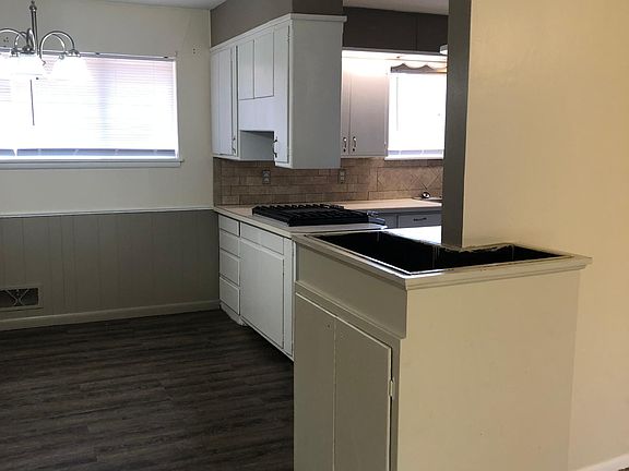 Kitchen opens into dining room. Original metal lined planter with storage cabinet underneath to the right. Dining opens into the living room.