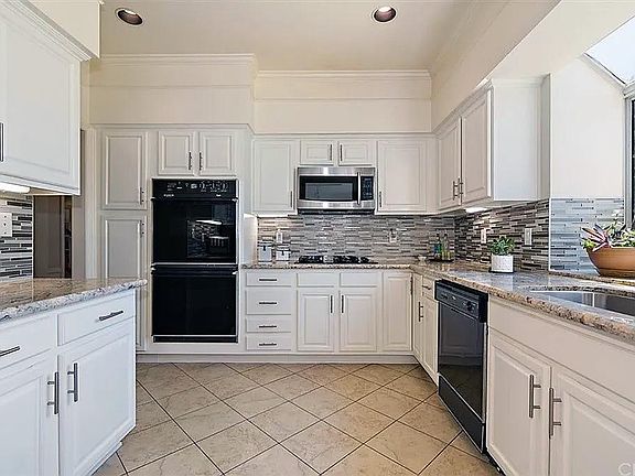 Recently remodeled Kitchen with Gorgeous Granite & Glass Tile Backsplash, Glistening White Cabinetry Is Both Functional And Beautiful
