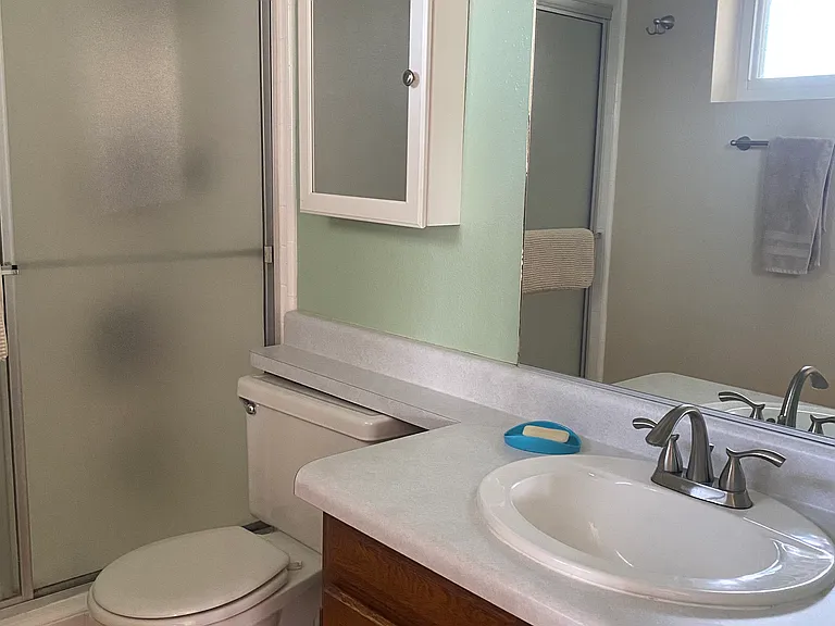 Bathroom with walk in shower. This is the only sink in the studio. Dishwashing pan provided.