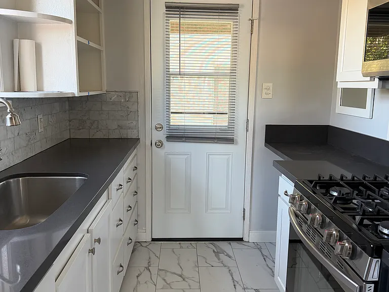 Kitchen with Luxury Plank tiles, Stainless steel refrigerator, microwave and stove. Dishwasher and built in desk. The back door leads to deckhand downstairs to Second Street.