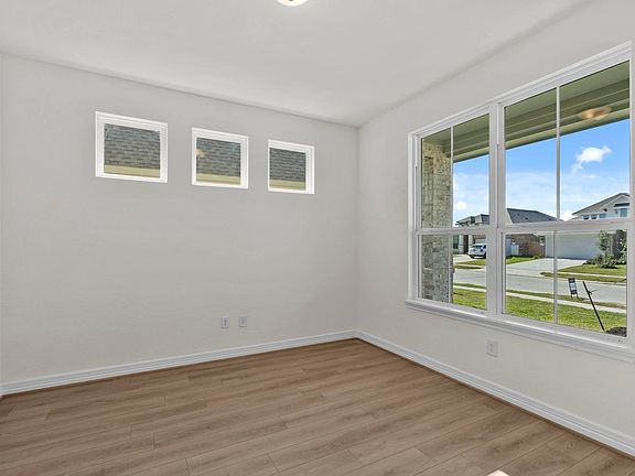 Bright and inspiring study featuring French doors, gorgeous flooring, and ample natural light.