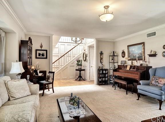 View from the formal living room, featuring crown molding, large windows, and fireplace.