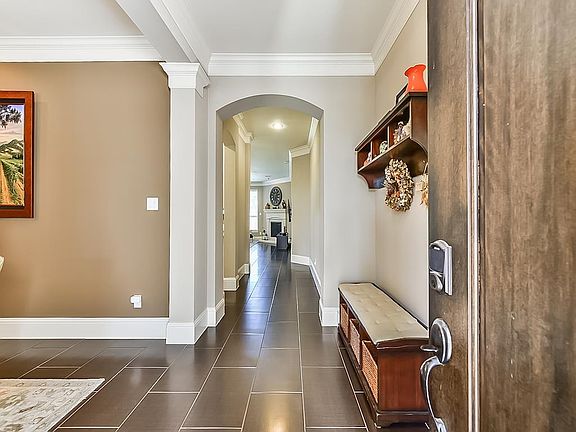 Entry greets you with crown molding, tile floors, and arched doorway leading you the generous living spaces.