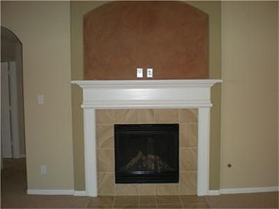 Gorgeous fireplace with mantel with arch frame.