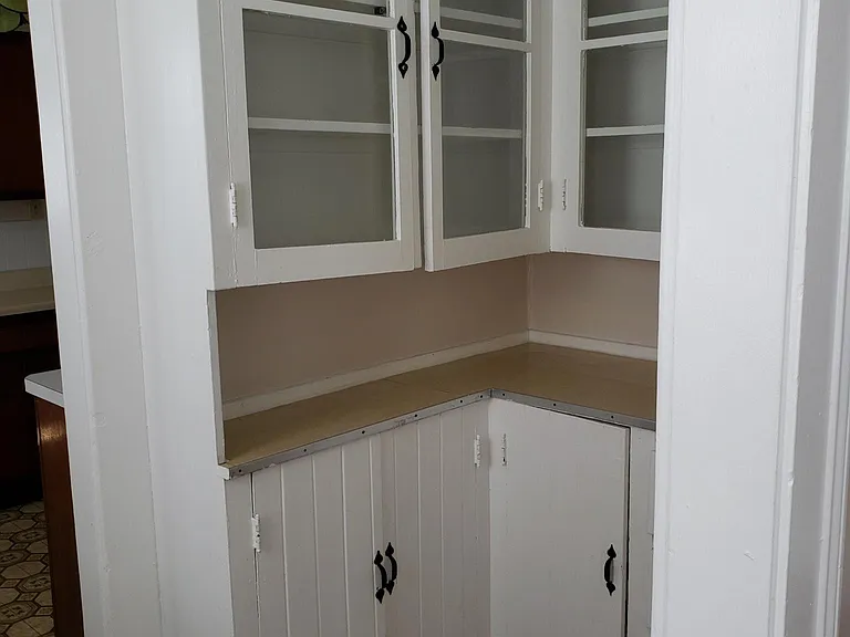 Another section of the kitchen space which includes a counter with over head storage and under storage areas
