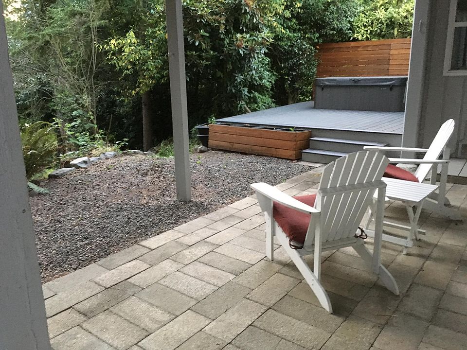 covered patio with additional trex deck and cedar privacy fence overlooking creek. hot tub no longer included