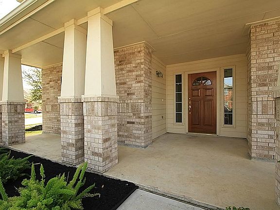 The inviting front entrance with dual sidelights provides a welcoming backdrop to the over-sized covered front porch.