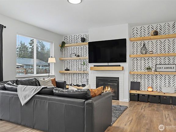View of your family room from the kitchen. I really love the propane gas fireplace for cooler days & nights, and the included built-ins on both sides of the fireplace, stunning!>