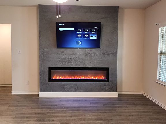 Livingroom with large electric fire place and a 58" Smart TV.