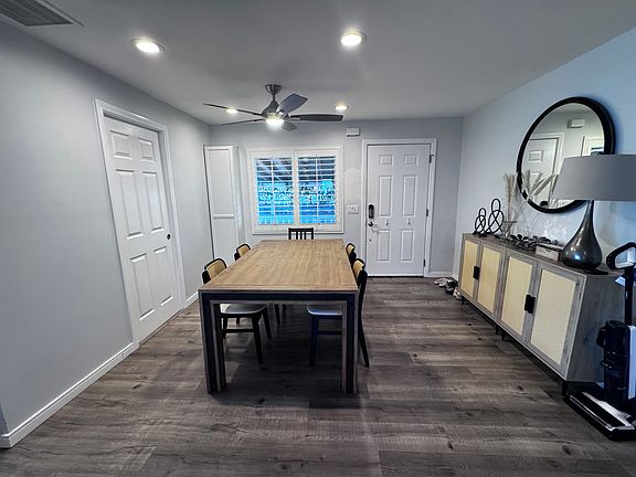 Entering off the driveway, is the dining room. The dining area has recessed lighting and a ceiling fan/light. The large laundry room is on the left side of this photo.