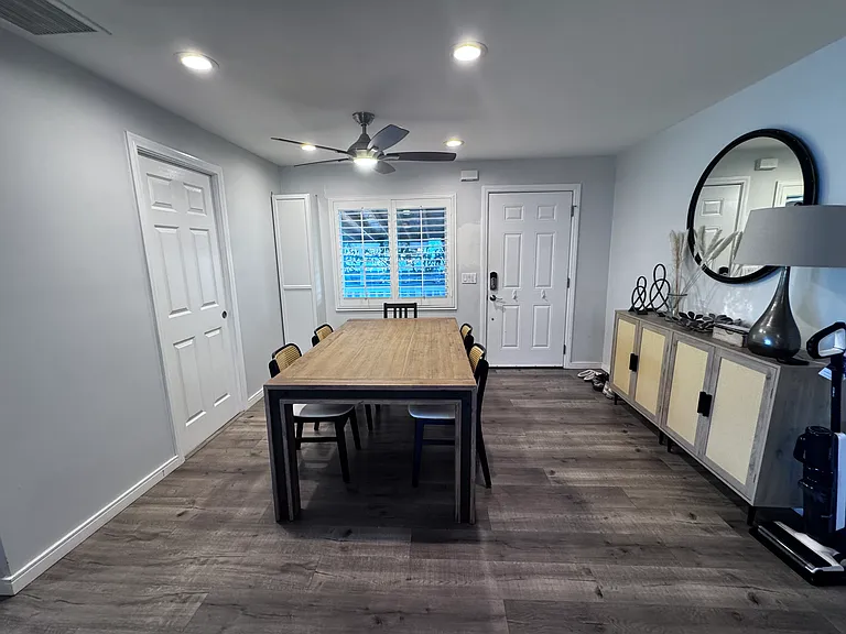 Entering off the driveway, is the dining room. The dining area has recessed lighting and a ceiling fan/light. The large laundry room is on the left side of this photo.