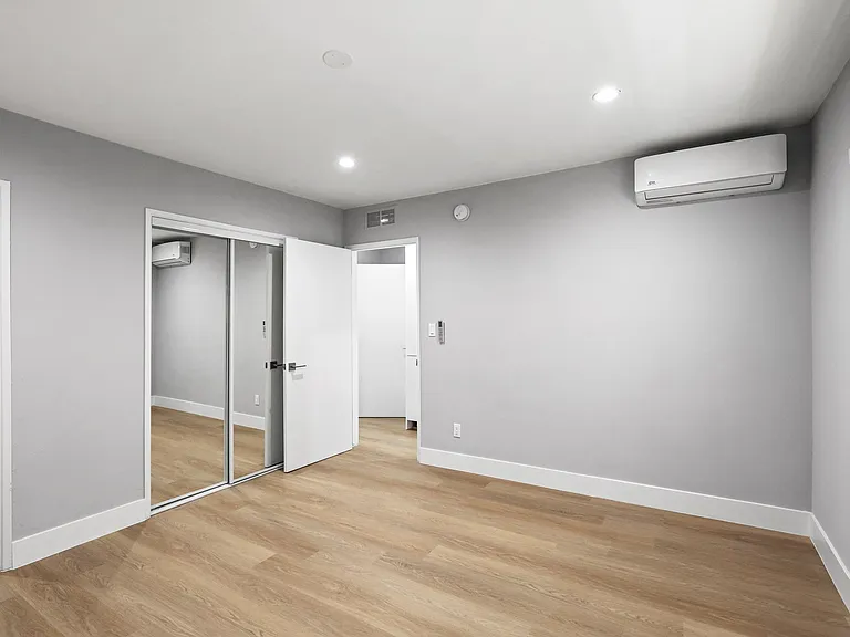 Bedroom with Two-Mirrored Closets, Recessed Lighting, and Vinyl Flooring