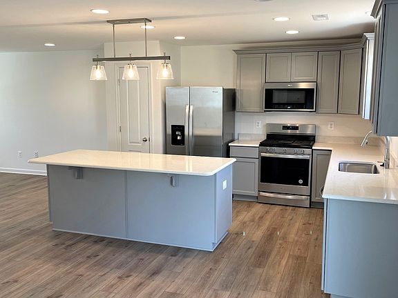 Island kitchen with gray cabinets in a DRB Homes Whitehall II plan in the Chesterfield community.