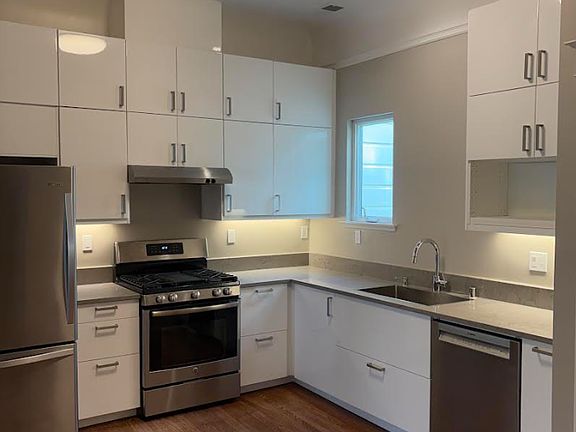 Remodeled, modern kitchen w/ stainless steel fridge, dishwasher, and stove and many cabinets