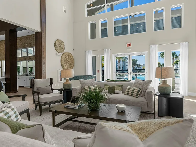 Experience comfort and style in this spacious living room featuring modern decor and panoramic pool views.