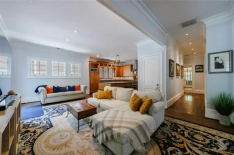 View from mudroom - step directly into the living room featuring an open floor plan living room and chefs kitchen. Hallway beyond living room leads to bedrooms and screened in back porch