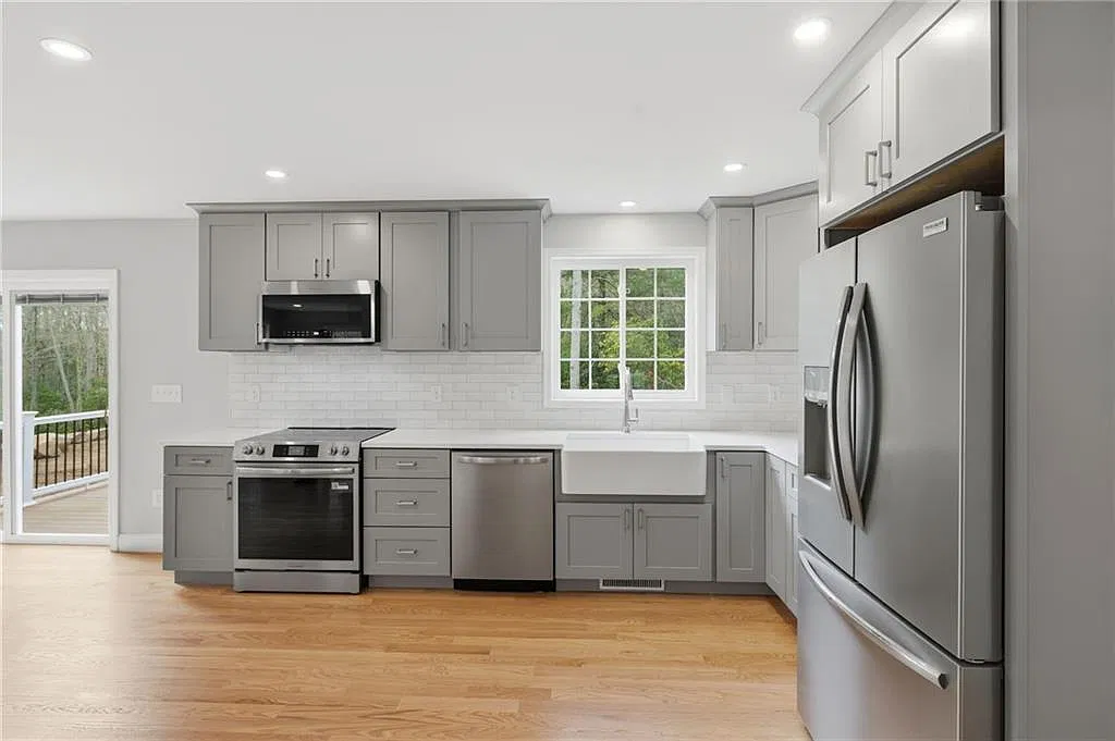 Bright gray kitchen at 14 Elaine Drive with farmhouse sink, quartz counters and stainless appliances
