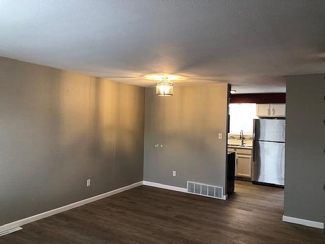 Dining Room photo taken from Entry to show Kitchen. All new paint, light fixture, and flooring.
