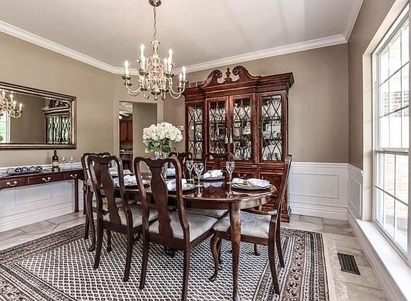 Formal dining room has wainscotting, crown molding and large tiled floor