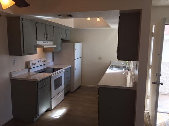 Galley kitchen with freshly painted cabinets, refinished countertops and newer appliances put in. Picture taken from dining room.