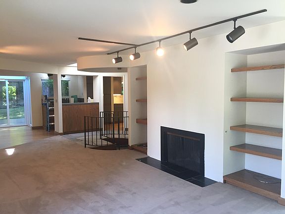 living room and spiral staircase to daylight basement level