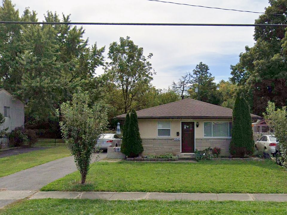 The front door of the house with two car space parking driveway and a small front yard.