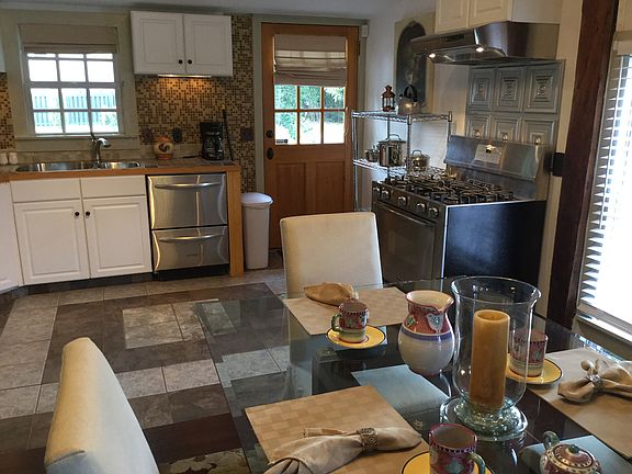 Charming cottage windows overlook the private garden, bringing natural light into the dining area and kitchen.
