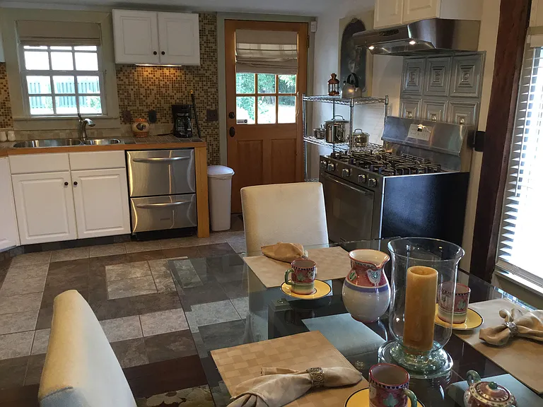 Charming cottage windows overlook the private garden, bringing natural light into the dining area and kitchen.