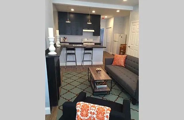 A view from the front windows, looking beyond the kitchen to the hallway and storage closets.